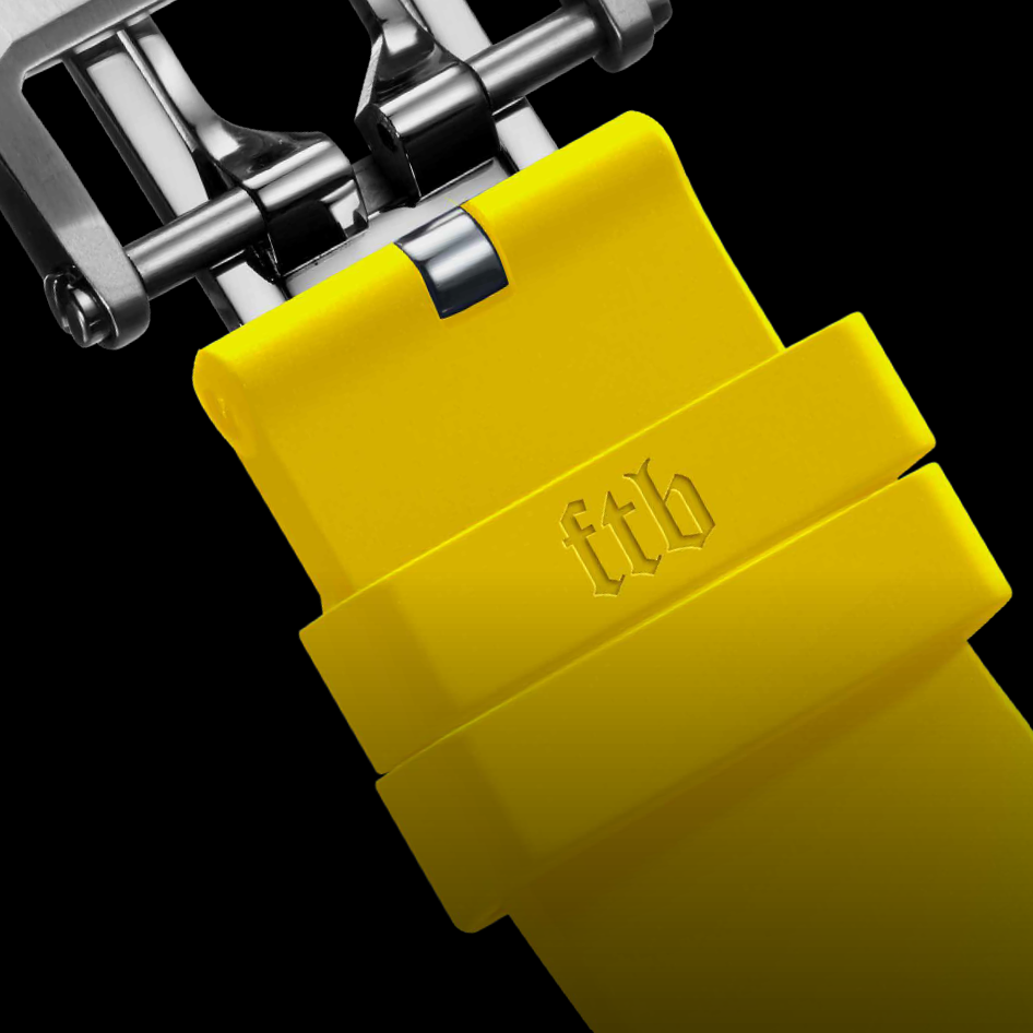 Close-up of a yellow watch strap with 'ftb' branding on a black background